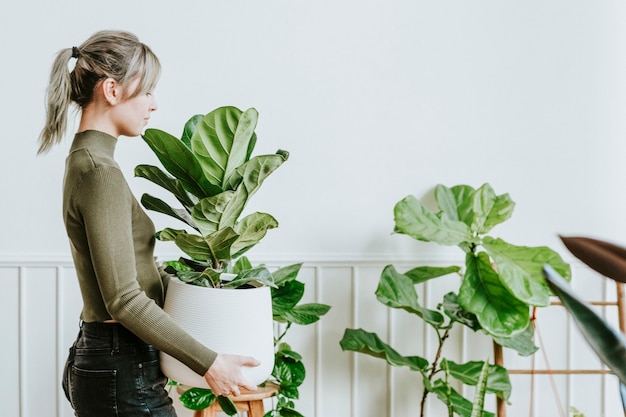 観葉植物を運ぶ幸せな女性