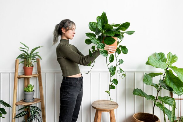 観葉植物を運ぶ幸せな女性