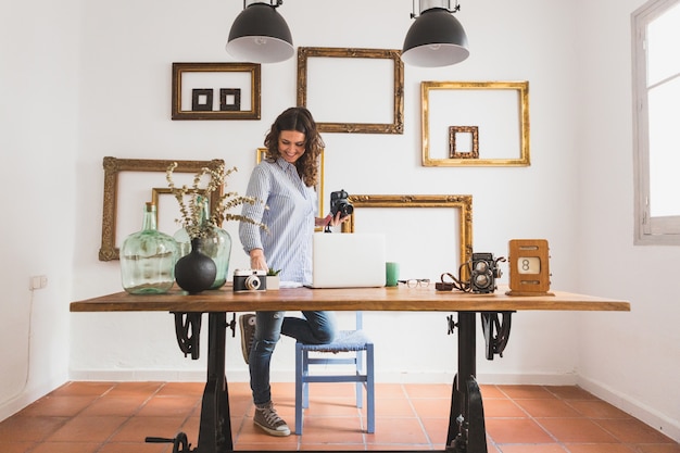 Happy woman checking documents and holding a camera