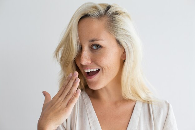 Happy woman checking freshness of her breathing