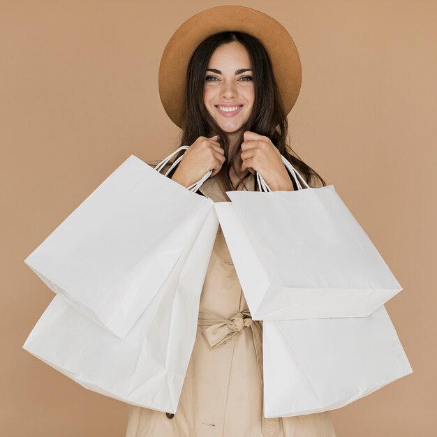 Happy woman in coat with many shopping nets