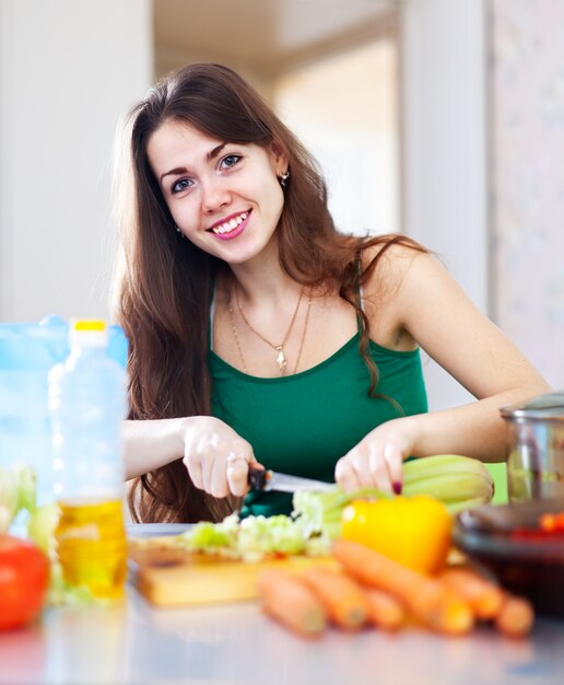 Happy  woman cutting vegetables