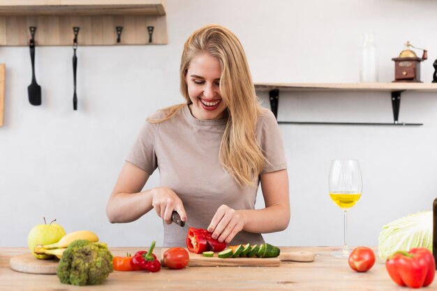 Happy woman cutting vegetables