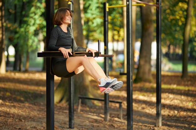 Happy woman doing fitness exercises on fresh air