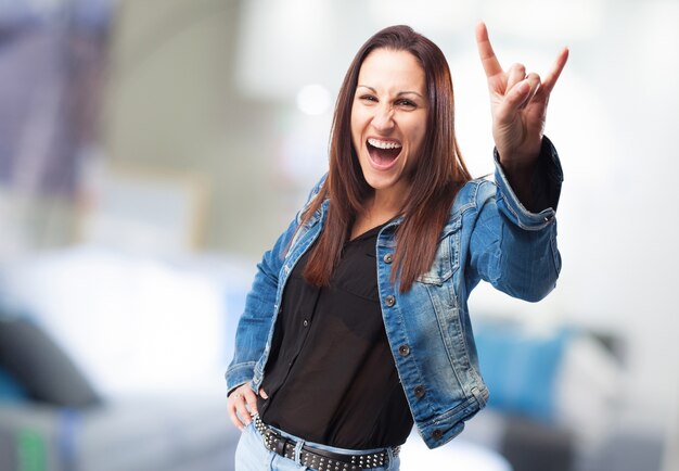 Happy woman doing rock gesture