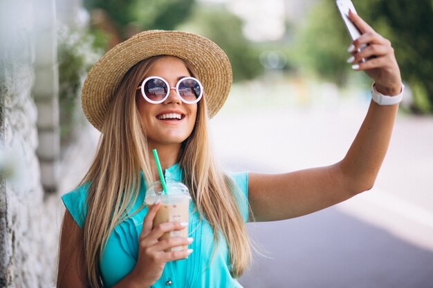 Happy woman drinking coffee and doing selfie