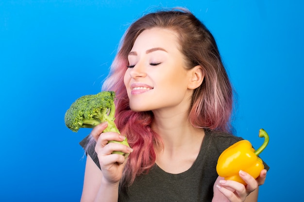 彼女の手で新鮮な野菜を楽しんで幸せな女