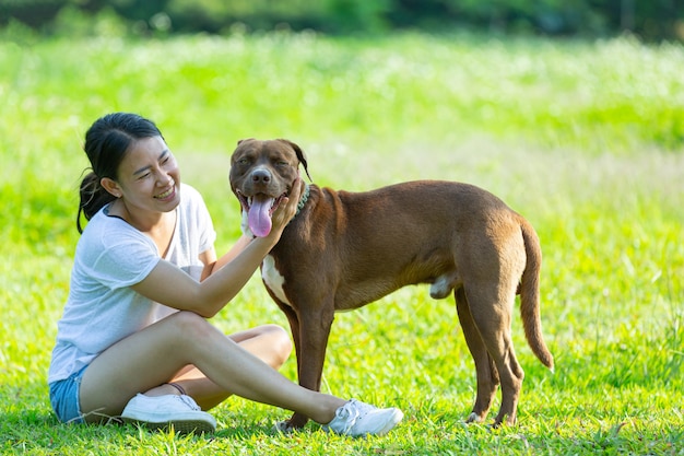 Счастливая женщина, наслаждаясь своей любимой собакой в парке.