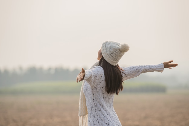 のどかな自然の中で楽しんで、自由を祝うと彼女の腕を上げる幸せな女