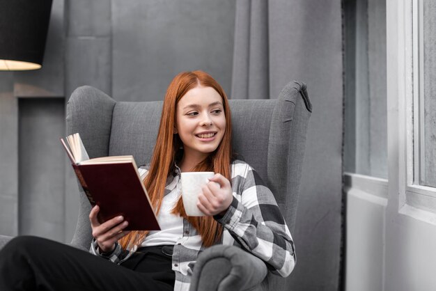 Happy woman enjoying reading book