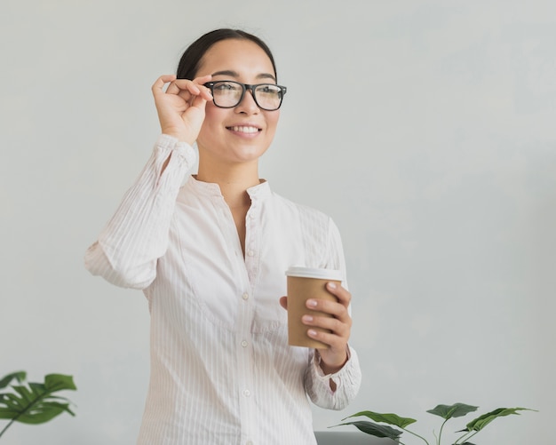 Free photo happy woman fixing eyeglasses