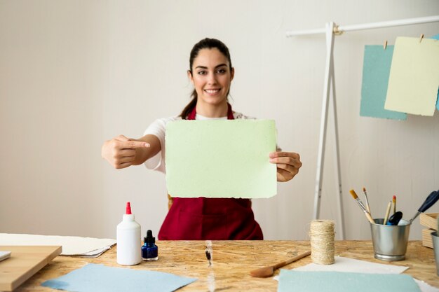 Happy woman gesturing while holding handmade paper