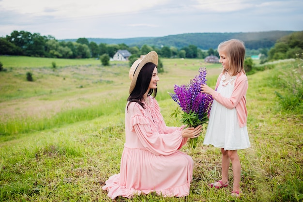 Foto gratuita la donna e la ragazza felici posano con il mazzo di lavanda sul campo