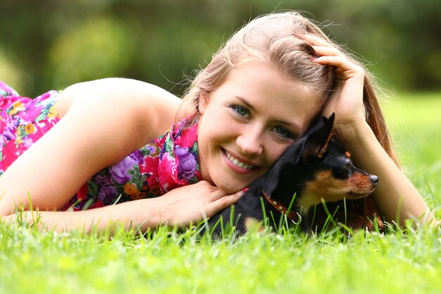 Happy woman and her cute dog on the grass