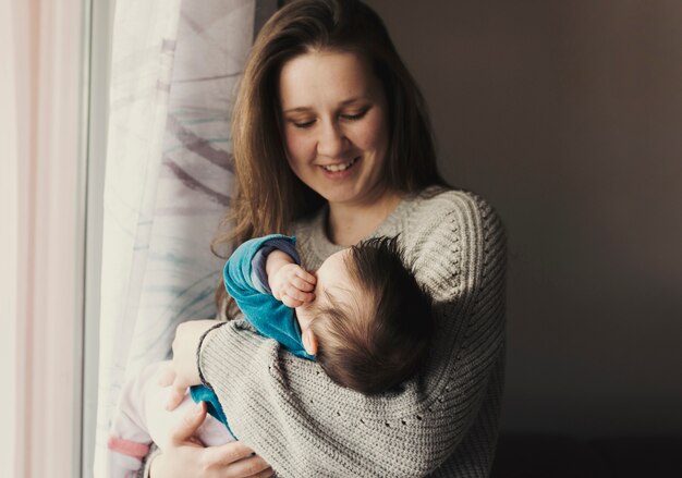 Happy woman holding baby in arms