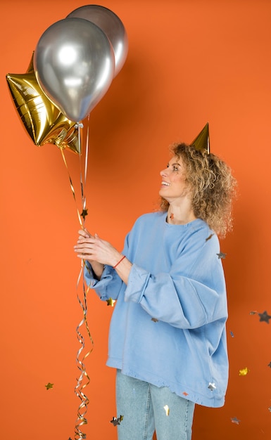 Free photo happy woman holding balloons