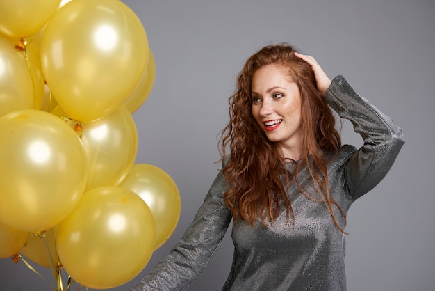 Happy woman holding bunch of balloons