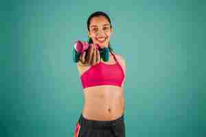 Free photo happy woman holding dumbbells