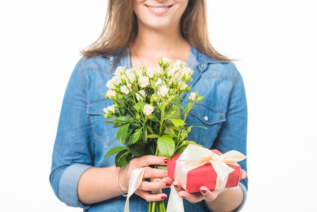 Happy woman holding gift box and fresh flowers
