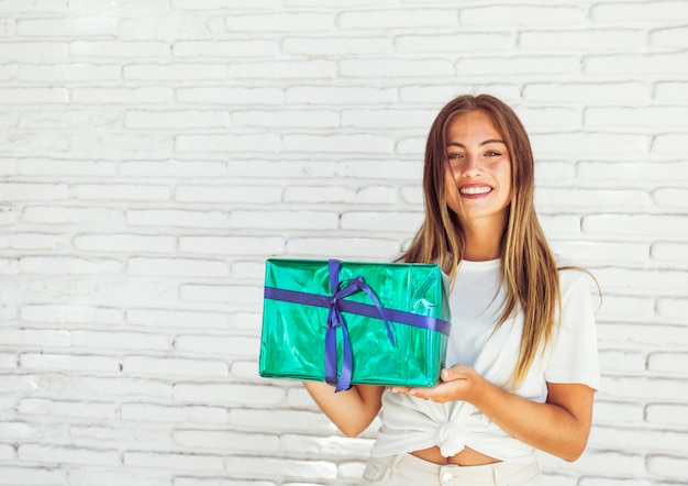 Happy woman holding green gift box