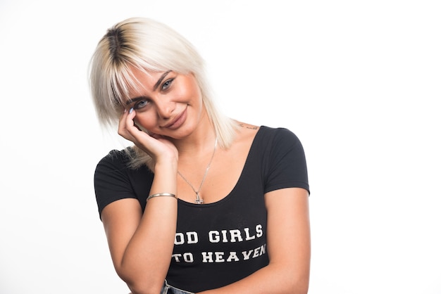 Free photo happy woman holding her face on white wall.