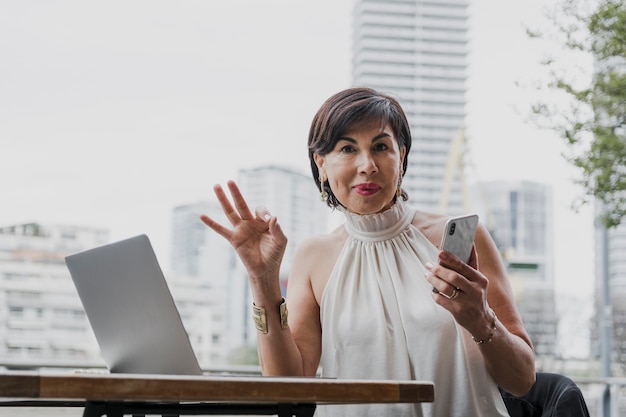 Happy woman holding a phone on urban background