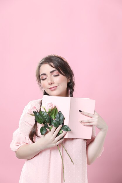 Happy woman holding roses and book