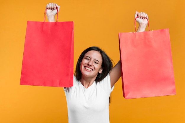 Free photo happy woman holding up sale shopping bags