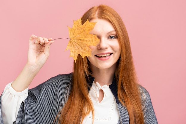 Foto gratuita donna felice che tiene foglia gialla