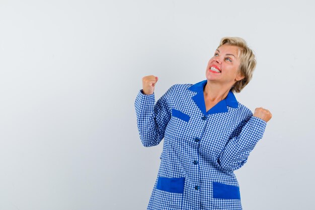 The happy woman is raising up her fists  on white background