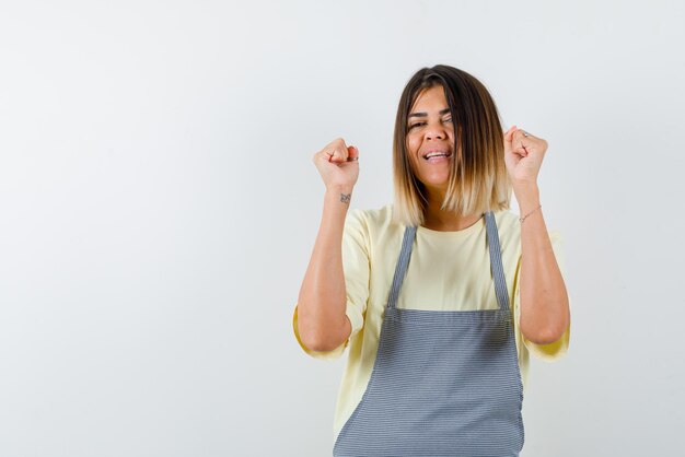 The  happy woman is raising up her fists on white background