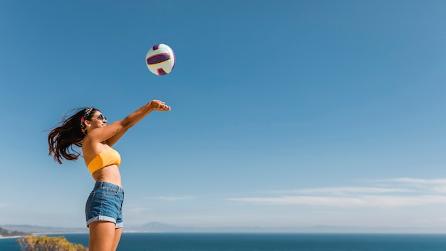 Free photo happy woman jumping and throwing ball