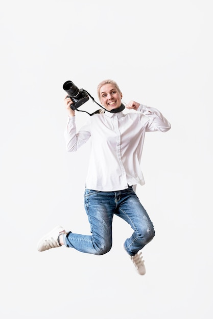 Happy woman jumping and using her camera photo