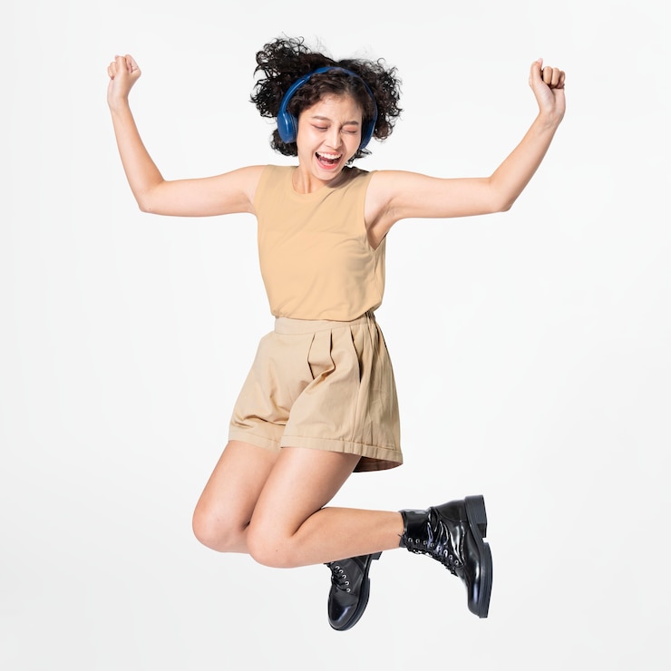 無料Photo 音楽に合わせて踊るヘッドフォンを着てジャンプする幸せな女性