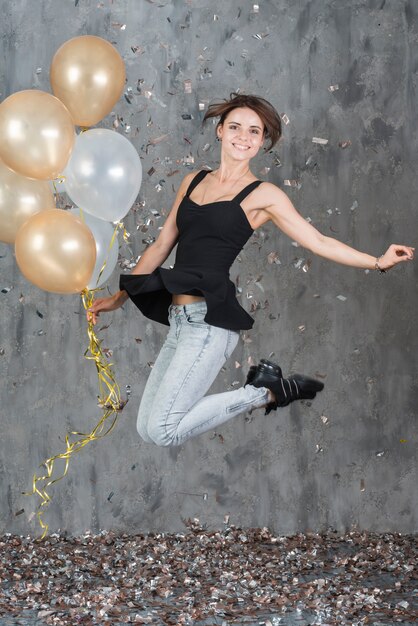 Free photo happy woman jumping with balloons