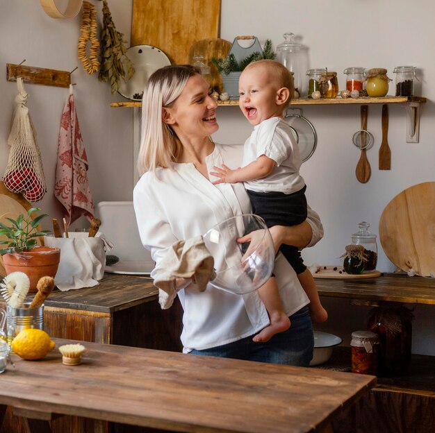 Foto gratuita donna felice e bambino al chiuso