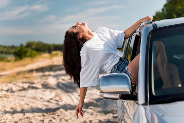 Счастливая женщина, опираясь на окно автомобиля