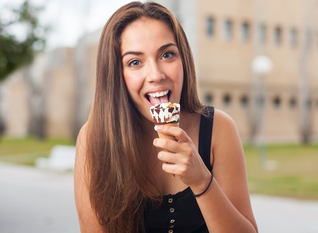 Foto gratuita donna felice lecca delizioso gelato.