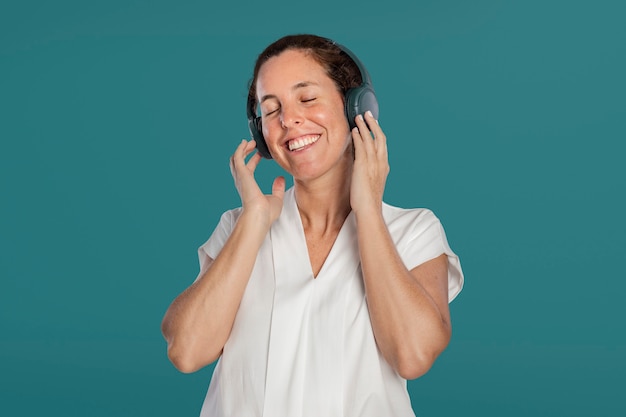 Happy woman listening to music from headphones