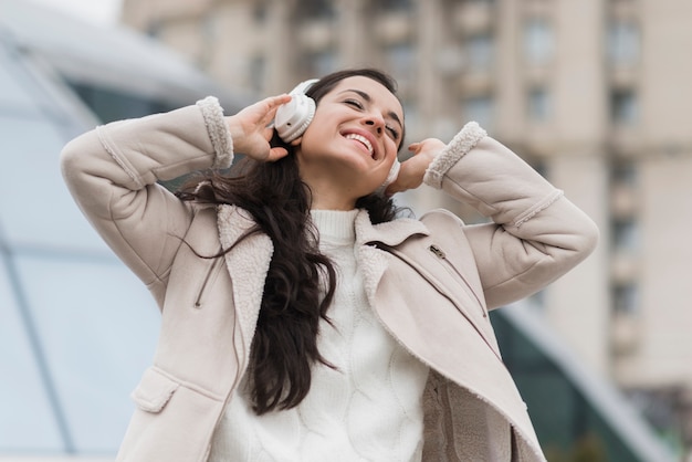 Foto gratuita donna felice che ascolta la musica sulle cuffie