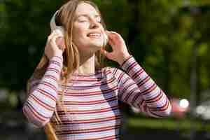 Foto gratuita donna felice che ascolta la musica