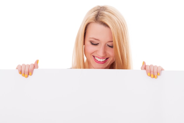 Happy woman looking down at empty billboard