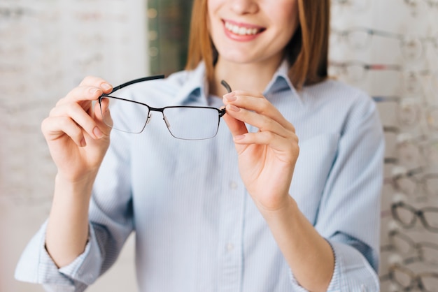 Happy woman looking for new glasses at optometrist