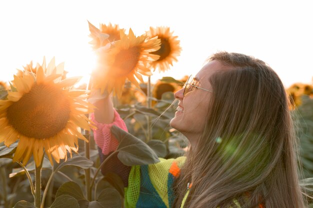 Happy woman looking at sunflower