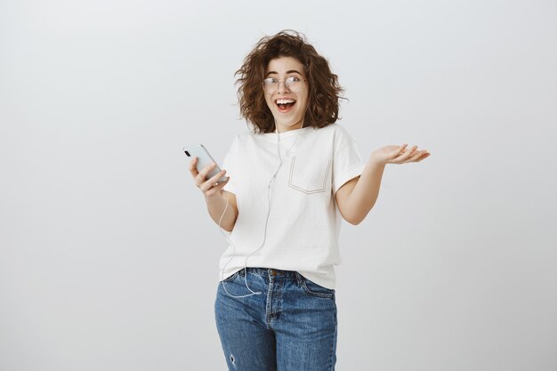 Happy woman looking surprised and excited from great news, reading message on phone and rejoicing