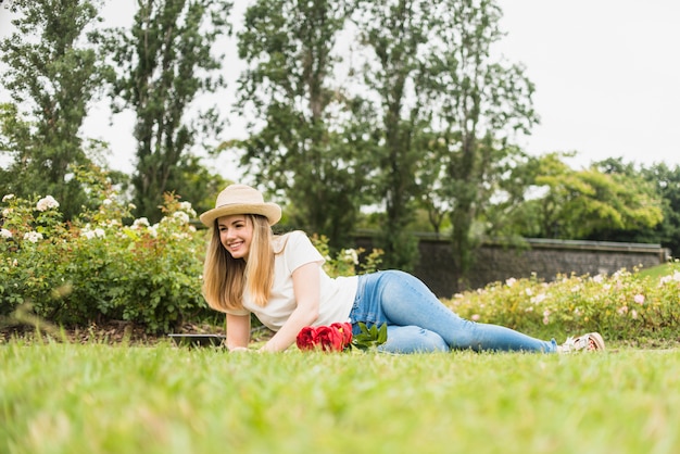 Free photo happy woman lying on grass