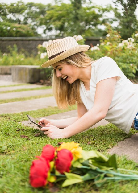 Happy woman lying on ground with tablet