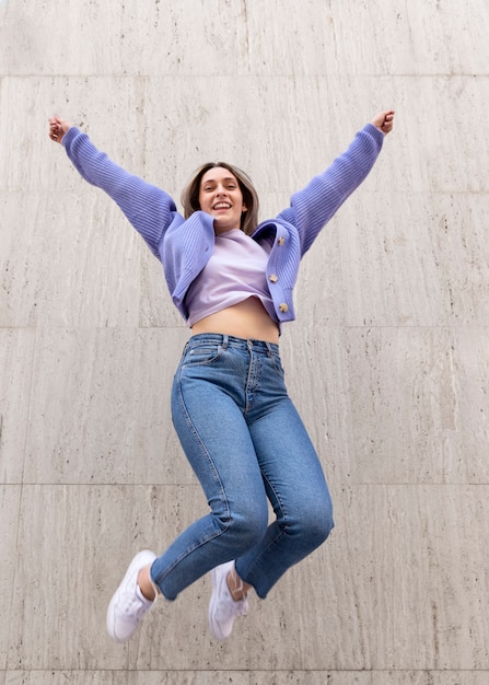 Free photo happy woman outdoors jumping up