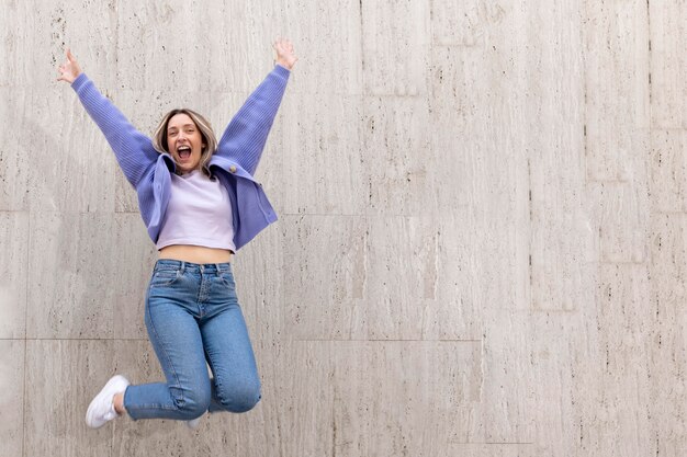 Happy woman outdoors jumping up