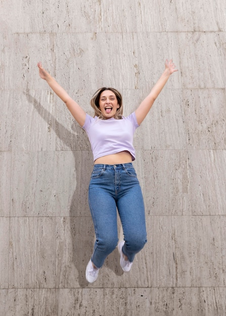 Free photo happy woman outdoors jumping up